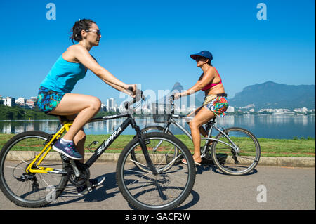 RIO DE JANEIRO - le 31 janvier 2016 : Les cyclistes passent dans le motion blur contre un matin calme vue sur Lagoa Rodrigo de Freitas lagoon. Banque D'Images