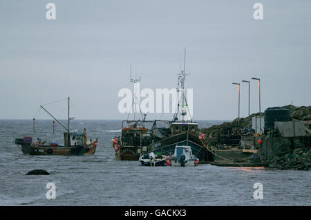 Pêcheur de homard Ross MacLennon Skipper du bateau « Carrie Anne » Retour à Milton Harbour sur l'île de Tiree avec Matelot William Walker (port de chapeau) Après l'atterrissage du homard dans l'océan Atlantique Banque D'Images