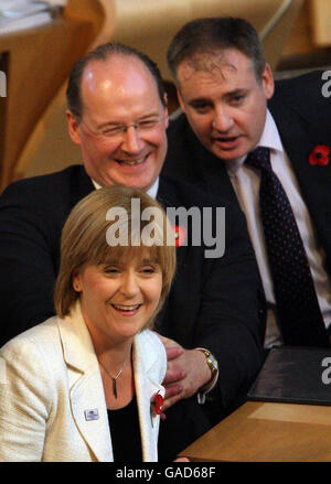 Nicola Sturgeon, vice-première ministre écossaise, pose des questions sous les noms de John Swinney, SNP MSP (à gauche) et Richard Lochhead SNP, MSP, lors de l'heure des questions au Parlement écossais d'Édimbourg. Banque D'Images