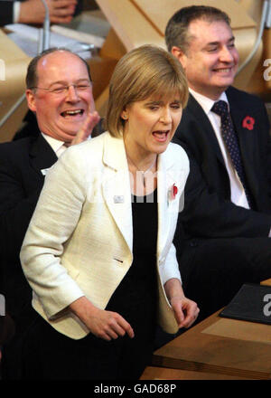 Nicola Sturgeon, vice-première ministre écossaise, pose des questions sous les noms de John Swinney, SNP MSP (à gauche) et Richard Lochhead SNP, MSP, lors de l'heure des questions au Parlement écossais d'Édimbourg. Banque D'Images