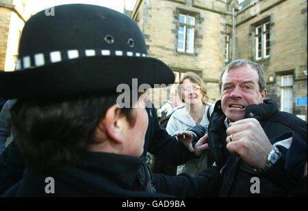 Le père de Vicky Hamilton Michael Hamilton (à droite) est brimenté par la police alors que Peter Tobin quitte le tribunal du shérif de Linlithgow à West Lothian après avoir été inculpé du meurtre de Vicky Hamilton. Banque D'Images