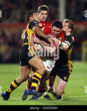 Llanelli Scarlets Stephen Jones est attaqué par les London Wasps Riki Flutey et Tom Rees lors du match Heineken Cup Pool 5 au Stradey Park, Llanelli. Banque D'Images