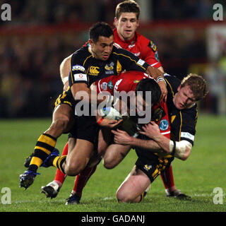 Llanelli Scarlets Stephen jones est Tackles par les London Wasps Riki Flutey et Tom Rees lors du match Heineken Cup Pool 5 au Stradey Park, Llanelli. Banque D'Images