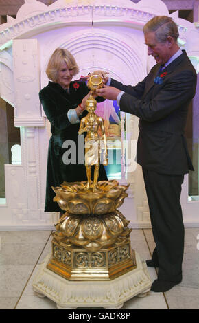 Le prince de Galles (à droite) et la duchesse de Cornouailles (à gauche) déversent l'eau sainte sur une figure de Murti lors d'une visite au temple Shri Swaminarayan à Neasden, dans le nord-ouest de Londres. Banque D'Images