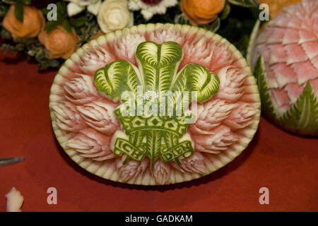 Un melon a été coupé dans la conception de l'emblème du prince de Galles, le Fleur de Lys, alors que le prince et la duchesse de Cornwall participent aux préparatifs de Diwali lors d'une visite au temple Shri Swaminarayan à Neasden, dans le nord-ouest de Londres. Banque D'Images