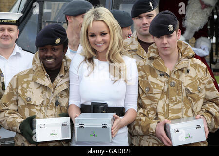 L'actrice et chanteuse Jennifer Ellison rit avec les membres du 9 Supply Regiment, Royal Logistics Corp après avoir aidé à charger un hélicoptère avec des boîtes de noël de « bas carré » pour distribution parmi le personnel de service à travers le monde à la caserne de Regents Park, Albany Street à Londres. Banque D'Images