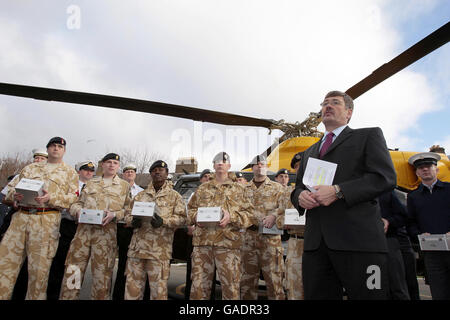 Le ministre d'État aux Forces armées, Bob Ainsworth, s'adresse aux militaires avant de se joindre à l'actrice et chanteuse Jennifer Ellison et au 9 Supply Regiment, Royal Logistics Corp aide à charger un hélicoptère avec des boîtes de noël de « bas carré » pour distribution parmi le personnel de service à travers le monde à la caserne de Regents Park, Albany Street à Londres. Banque D'Images