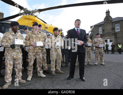 Le ministre d'État aux Forces armées, Bob Ainsworth, s'adresse aux militaires avant de se joindre à l'actrice et chanteuse Jennifer Ellison et au 9 Supply Regiment, Royal Logistics Corp aide à charger un hélicoptère avec des boîtes de noël de « bas carré » pour distribution parmi le personnel de service à travers le monde à la caserne de Regents Park, Albany Street à Londres. Banque D'Images