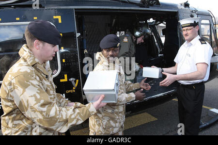 Les membres du 9 Supply Regiment, Royal Logistics Corp aident à charger un hélicoptère avec des boîtes de noël de « bas carré » pour distribution parmi le personnel de service dans le monde entier à la caserne de Regents Park, Albany Street à Londres. Banque D'Images