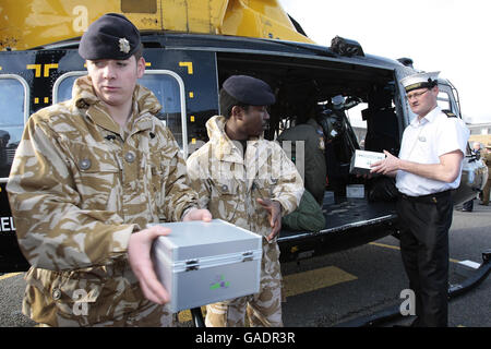 Les membres du 9 Supply Regiment, Royal Logistics Corp aident à charger un hélicoptère avec des boîtes de noël de « bas carré » pour distribution parmi le personnel de service dans le monde entier à la caserne de Regents Park, Albany Street à Londres. Banque D'Images