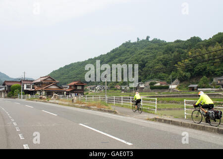 Deux cyclistes de randonnée sur un chemin dans la campagne japonaise. Banque D'Images