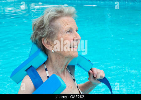 Active senior woman dans la piscine, faire des exercices Banque D'Images