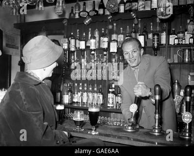 Henry Cooper, champion britannique et du Commonwealth de poids lourd, tire une pinte De courage amer comme il aide dehors derrière la barre De « The George » Banque D'Images