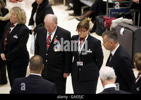 Le personnel d'enregistrement de British Airways se tient pendant le silence de 2 minutes du dimanche du souvenir dans le terminal 1 de Heathrow, à l'ouest de Londres. Banque D'Images