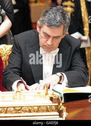 Le Premier ministre britannique Gordon Brown signe le livre des visiteurs distingués au banquet du Lord Mayor au Guildhall, dans le centre de Londres. Banque D'Images