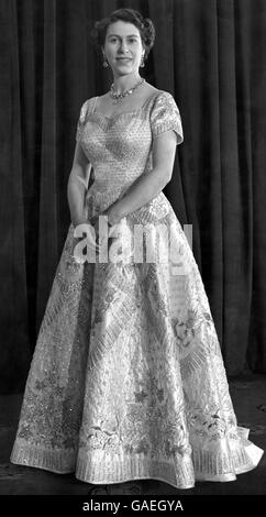 Portrait de sa Majesté la reine Elizabeth II dans le trône Chambre Buckingham Palace portant sa magnifique robe de couronnement conçue par Norman Hartnell 1953 satin blanc cousu avec des milliers de perles et broderie en cristal Banque D'Images