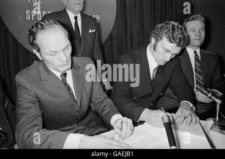 (G-D) Henry Cooper et Joe Bugner signent des contrats pour se combattre en mars 1971 Banque D'Images