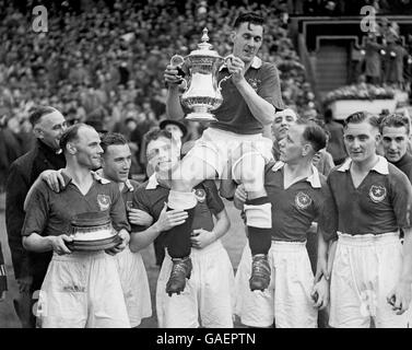 Jimmy Guthrie, capitaine de Portsmouth, détient la FA Cup en aloft il est présidé par ses coéquipiers Banque D'Images