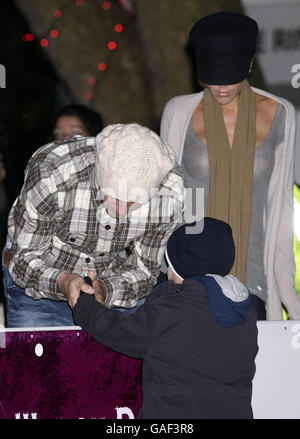 David Beckham a réchauffé les mains de son fils Romeo - tandis que la femme Victoria regarde - lors d'une visite à la patinoire Winter Wonderland de Hyde Park, dans le centre de Londres. Banque D'Images