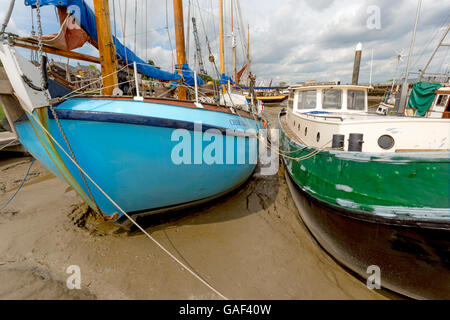 Dream yacht à voile et barge dressé sur le sable et boue limoneuse sur la rivière Chelmer, Maldon, Essex, Angleterre, Royaume-Uni. Banque D'Images