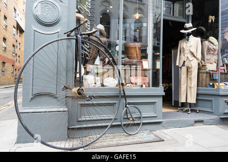 Un Penny Farthing location garés devant une boutique de Londres Banque D'Images