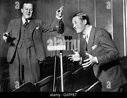 L'acteur et chanteur français Maurice Chevalier à Paris chantant au microphone, avec le chef de bande britannique Jack Hylton. Banque D'Images