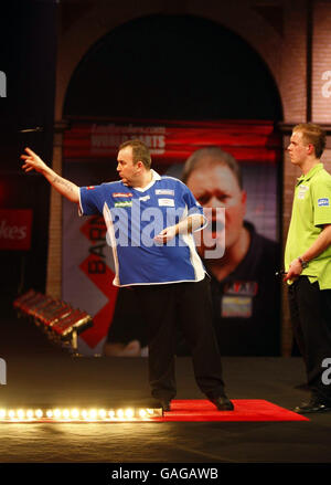 Phil Taylor en Angleterre en action contre Michael van Gerwen aux pays-Bas pendant le Championnat du monde des fléchettes à Alexandra Palace, Londres. Banque D'Images