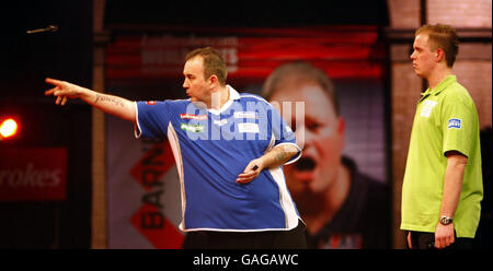 Michael van Gerwen, de Hollande, regarde Phil Taylor en action pendant le Championnat du monde des fléchettes à Alexandra Palace, Londres. Banque D'Images