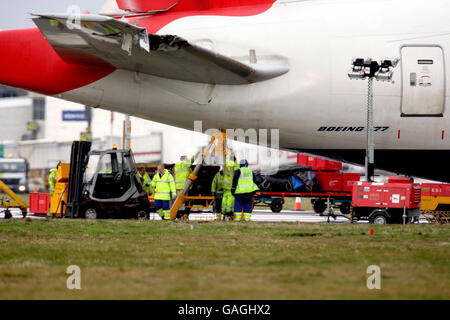 Les enquêteurs regardent le Boeing 777 de British Airways qui se trouve au pied de la piste sud alors que les enquêteurs tentent de déterminer aujourd'hui ce qui a causé le dysfonctionnement à bord du vol BA038 à l'approche de l'aéroport d'Heathrow. Banque D'Images