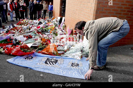 Un fan de Manchester City jette un drapeau à Old Trafford avant un service commémoratif pour l'accident aérien de Munich, à l'occasion du 50e anniversaire de la catastrophe au cours de laquelle 8 joueurs de Manchester United sont morts. Banque D'Images