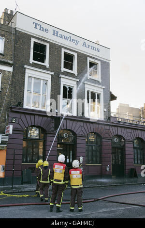 Les pompiers continuent de s'humidifier après un grand incendie qui a déchiré le pub Hawley Arms et les environs du marché Camden de Londres. Banque D'Images