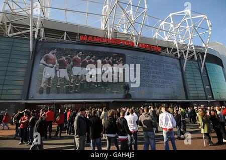 La statue de Sir Matt Busby et la bannière à l'extérieur d'Old Trafford en tant que fans de Manchester United font leur chemin dans le sol. Banque D'Images