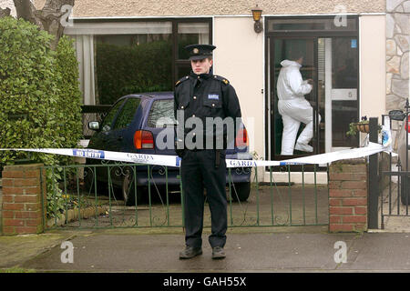 Homme détenu après un vol à main armée.Les officiers de Gardai fourent une maison familiale où a eu lieu une tentative de vol, à Dublin, en Irlande. Banque D'Images