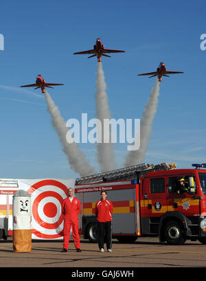 Les flèches rouges effectuent un survol des appareils du Lincoln Fire Service et du Red four Flight Lieutenant Graham Duff et Charlotte Spencer du Lincoln City Ladies football Club dans le cadre du lancement de la campagne nationale de la Journée de non-fumeurs (12 mars 2008) à la RAF Scampton, Lincolnshire. Banque D'Images