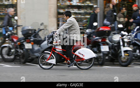 Les gens de Barcelone, en Espagne, utilisant des vélos loués pour se déplacer dans la ville. Le nouveau système appelé Bicing permet aux utilisateurs enregistrés de faire un cycle à partir de n'importe laquelle des 100 stations automatisées de la capitale catalane et de faire un trajet jusqu'à deux heures avant de le retourner à n'importe quelle autre station. Les paniers avant des vélos sont verrouillés sur un rail qui se libère lorsqu'une carte électronique est placée contre le consul de la machine. Le système est promu comme une forme supplémentaire de transport public et ne coûte que 0.3 euros par 30 minutes plus une charge annuelle de 24 euros. Banque D'Images