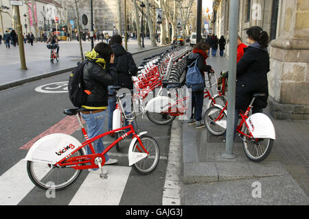 Les gens de Barcelone, en Espagne, utilisant des vélos loués pour se déplacer dans la ville. Le nouveau système appelé Bicing permet aux utilisateurs enregistrés de faire un cycle à partir de n'importe laquelle des 100 stations automatisées de la capitale catalane et de faire un trajet jusqu'à deux heures avant de le retourner à n'importe quelle autre station. Les paniers avant des vélos sont verrouillés sur un rail qui se libère lorsqu'une carte électronique est placée contre le consul de la machine. Le système est promu comme une forme supplémentaire de transport public et ne coûte que 0.3 euros par 30 minutes plus une charge annuelle de 24 euros. Banque D'Images