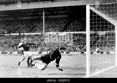 Roger Hunt d'Angleterre (deuxième l) Commence à célébrer comme gardien de but de l'Allemagne de l'Ouest Hans Tilkowski (r) regarde autour de vous pour voir la balle rebondir sur le Ligne pour le troisième objectif controversé de l'Angleterre Banque D'Images