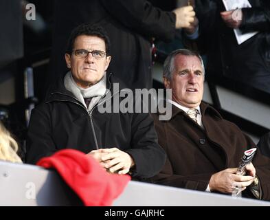 Fabio Capello, directeur de l'Angleterre, et Ray Clemence, entraîneur de gardien de but (à droite) observer la correspondance dans les supports Banque D'Images