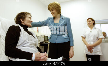 la secrétaire écossaise à la santé Nicola Sturgeon (au centre) discute avec le patient Alisa Evans (à gauche) lors d'une visite à l'hôpital St John's de Livingston, en Écosse. Banque D'Images