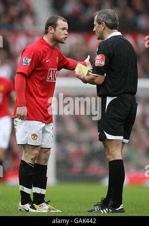 Wayne Rooney, de Manchester United, se défend avec l'arbitre Martin Atkinson après Être réservé pour un défi sur Niko Kranjcar de Portsmouth Banque D'Images