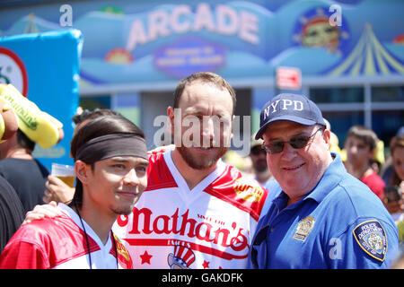 New York City, United States. Le 04 juillet, 2016. Concurrents Joey Chestnut & Matt Stonie posent avec NYPD officer avant de contester. Huit fois la célèbre Nathan Quatrième de juillet Hot Dog eating contest winner Joey Chestnut a repris la couronne qu'il a perdu l'année dernière à Matt Stonie Stonie en défaisant manger 70 hot dogs & brioches lors du célèbre Concours du centenaire Nathan à Coney Island. Credit : Andy Katz/Pacific Press/Alamy Live News Banque D'Images