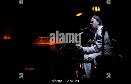 Neil Young exécute son set acoustique de la première moitié de son concert au Hammersmith Apollo à l'ouest de Londres. Banque D'Images