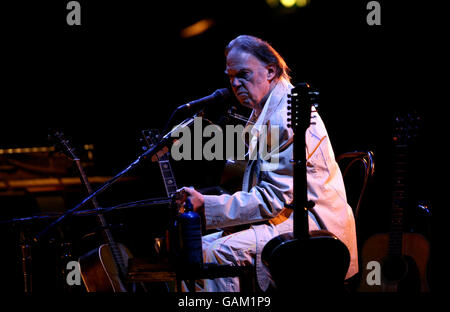 Neil Young exécute son set acoustique de la première moitié de son concert au Hammersmith Apollo à l'ouest de Londres. Banque D'Images