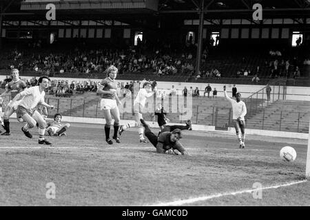 Kerry Dixon (deuxième en partant de la gauche) met le ballon devant le gardien de Glasgow Nicky Walker pour marquer Chelsea et reçoit un salut de victoire de l'équipier Paul Canoville lors d'un match de tonights au pont Stamford, qui a été en aide au Fonds d'appel de Bradford City pour les victimes de l'incendie de samedi. Banque D'Images