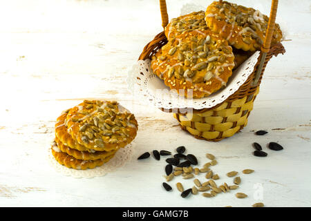 Cookies faits maison avec des graines de tournesol et le sucre à glacer dans un panier en osier blanc sur un fond de bois. Les cookies. Cookie. Pâtisserie. Banque D'Images