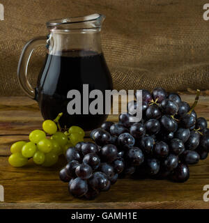 Grappe de raisin et une cruche de vin sur un fond de bois sombre. Grappe de raisins. Les raisins de la grappe. Les raisins de table. Les raisins. Raisin. Glas Banque D'Images