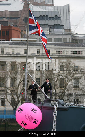 Les anciens combattants de la guerre de Corée, Ted Hill, sont partis, dans ses années 70, et Bob Blackwell, 78,Accueillez un ballon géant de la Loterie nationale à bord de leur ancien navire, le HMS Belfast, sur la Tamise, à Londres. Banque D'Images