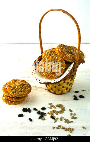 Les cookies avec des graines de tournesol et le sucre à glacer dans un panier en osier blanc sur un fond de bois. Les cookies. Cookie. Pâtisserie. Des Banque D'Images