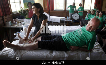 Susanne Baird, esthéticienne, cirer les jambes du comique Fred MacAulay pendant sa tentative de cirage de jambe record du monde à Édimbourg. Banque D'Images