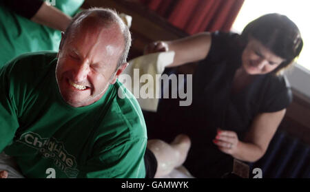 Susanne Baird, esthéticienne, cirer les jambes du comique Fred MacAulay pendant sa tentative de cirage de jambe record du monde à Édimbourg. Banque D'Images